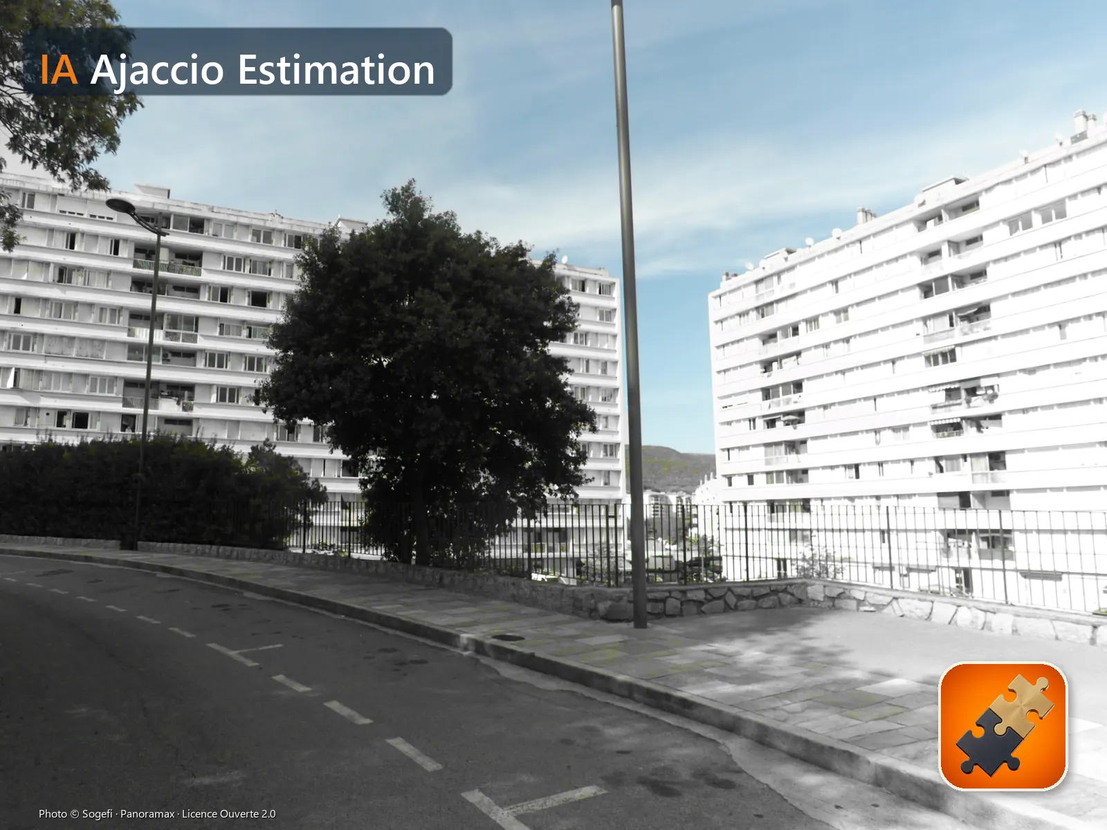 La Résidence des Cannes, place des Cannes, dans le quartier des Cannes (Ajaccio), vue depuis la rue en septembre 2022 : ses deux barres en noir et blanc, arbres, collines et ciel en couleur